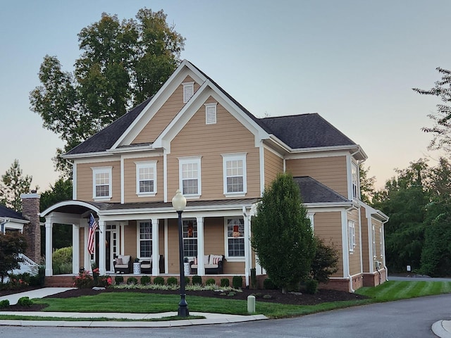 view of front of home featuring covered porch and a front yard