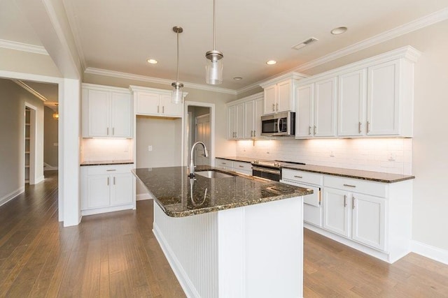 kitchen featuring an island with sink, appliances with stainless steel finishes, white cabinets, and a sink