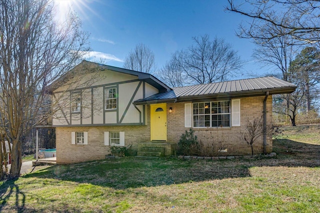 split level home featuring metal roof, brick siding, a front lawn, and stucco siding