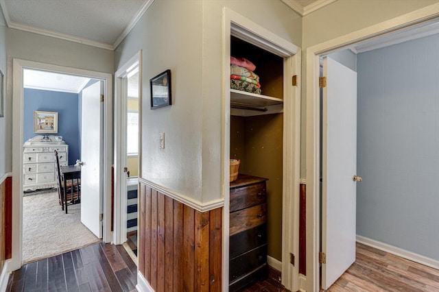 hall with ornamental molding, baseboards, and wood finished floors