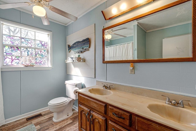 full bathroom with double vanity, visible vents, a sink, and wood finished floors