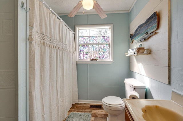 bathroom with visible vents, toilet, ceiling fan, wood finished floors, and vanity