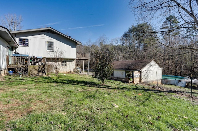 view of yard with a wooden deck, an outdoor pool, stairs, an outdoor structure, and a shed