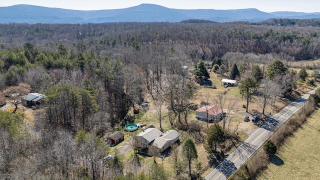 birds eye view of property featuring a mountain view and a view of trees