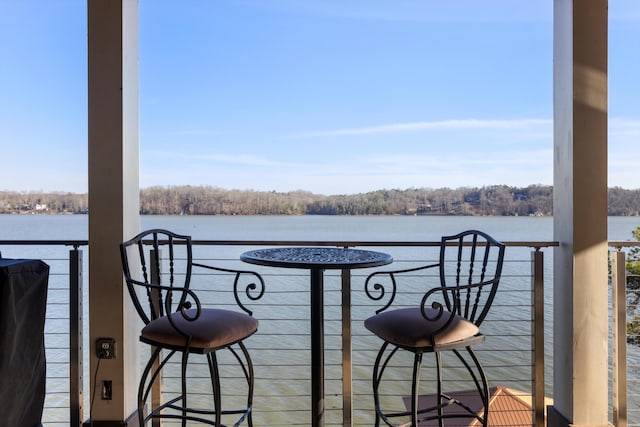 balcony with a forest view and a water view