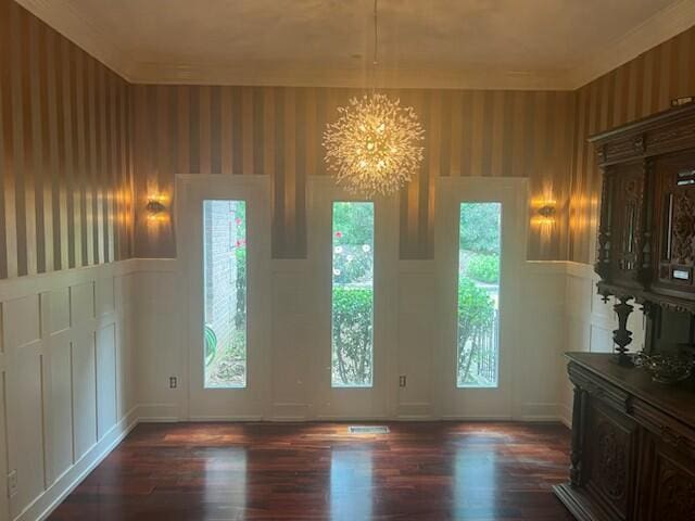 interior space featuring a chandelier, wainscoting, dark wood finished floors, and wallpapered walls