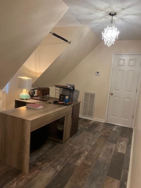 office area featuring visible vents, baseboards, vaulted ceiling, wood tiled floor, and an inviting chandelier