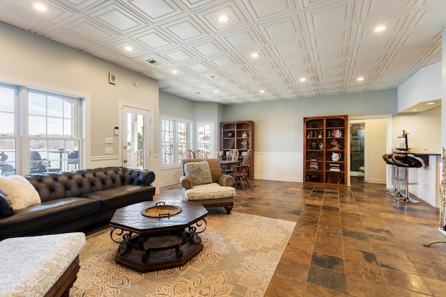 living area featuring an ornate ceiling, baseboards, and recessed lighting