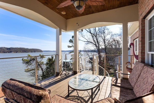 wooden deck featuring a ceiling fan and a water view