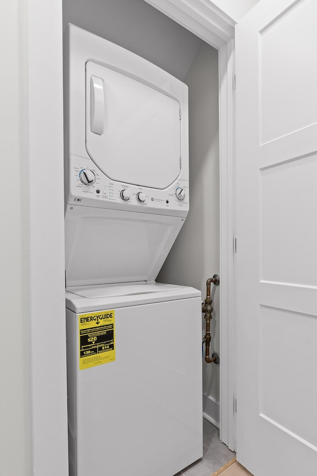 clothes washing area featuring laundry area and stacked washer and clothes dryer