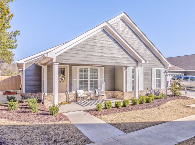 craftsman inspired home featuring ceiling fan, fence, a porch, and brick siding