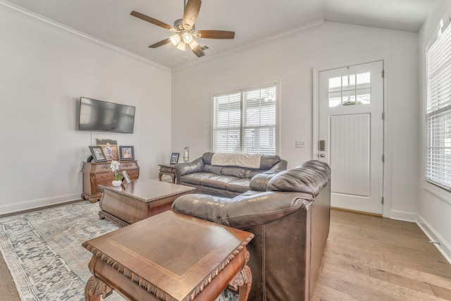 living room with ornamental molding, light wood-type flooring, a wealth of natural light, and baseboards