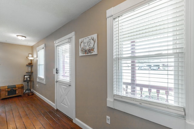 foyer featuring dark wood-style floors, a textured ceiling, and baseboards