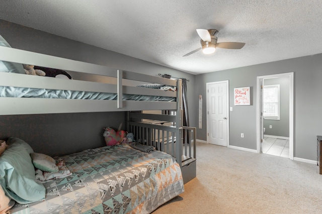 bedroom featuring a textured ceiling, ceiling fan, baseboards, and light colored carpet