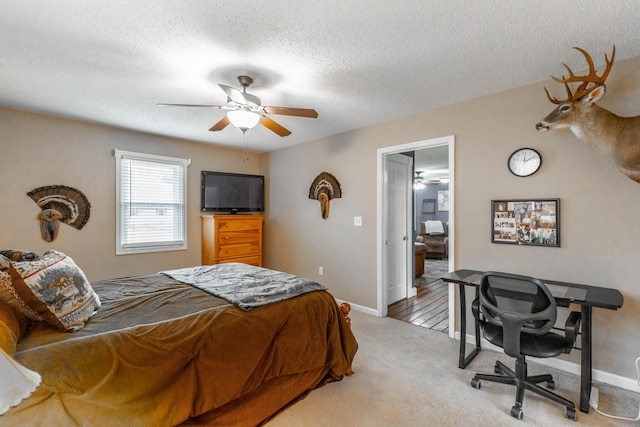 carpeted bedroom featuring a ceiling fan, a textured ceiling, and baseboards