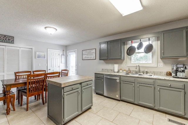 kitchen featuring a center island, light countertops, visible vents, a sink, and dishwasher