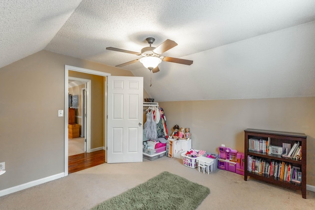 rec room featuring lofted ceiling, carpet, a textured ceiling, and baseboards