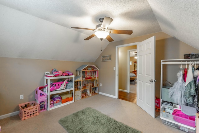 rec room with a textured ceiling, carpet flooring, lofted ceiling, and baseboards