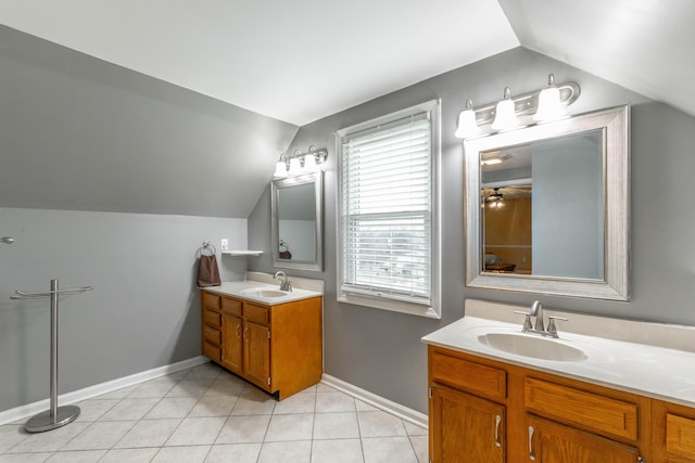 bathroom with two vanities, vaulted ceiling, a sink, and tile patterned floors