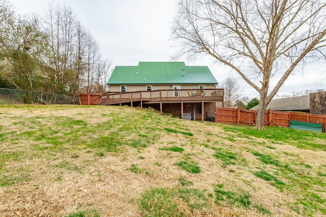 back of house with a deck, a yard, and a fenced backyard