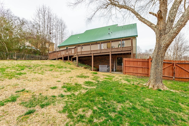 rear view of house with a fenced backyard, metal roof, and a yard