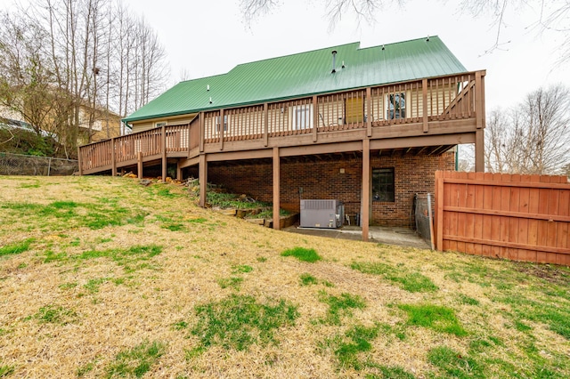 rear view of property featuring central air condition unit, metal roof, fence, and a deck