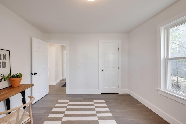 bedroom featuring multiple windows, baseboards, and wood finished floors