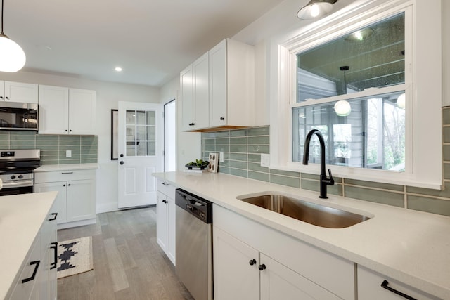 kitchen with light countertops, appliances with stainless steel finishes, and a sink