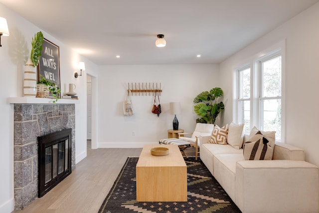 living room featuring recessed lighting, a fireplace, wood finished floors, and baseboards