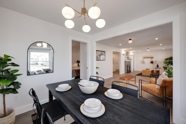 dining area featuring a fireplace, wood finished floors, and baseboards