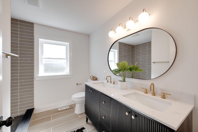 full bath with a healthy amount of sunlight, visible vents, and a sink