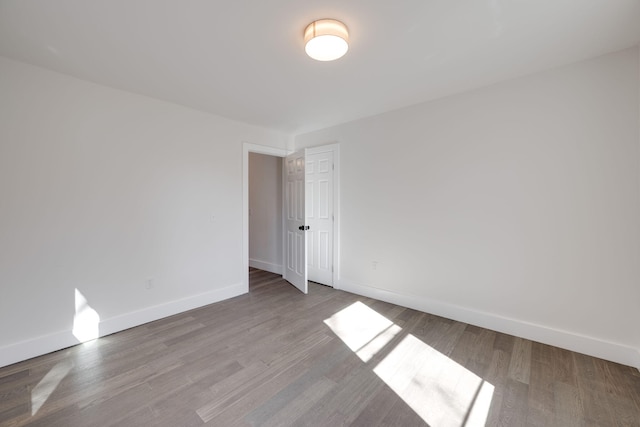 empty room with light wood finished floors and baseboards