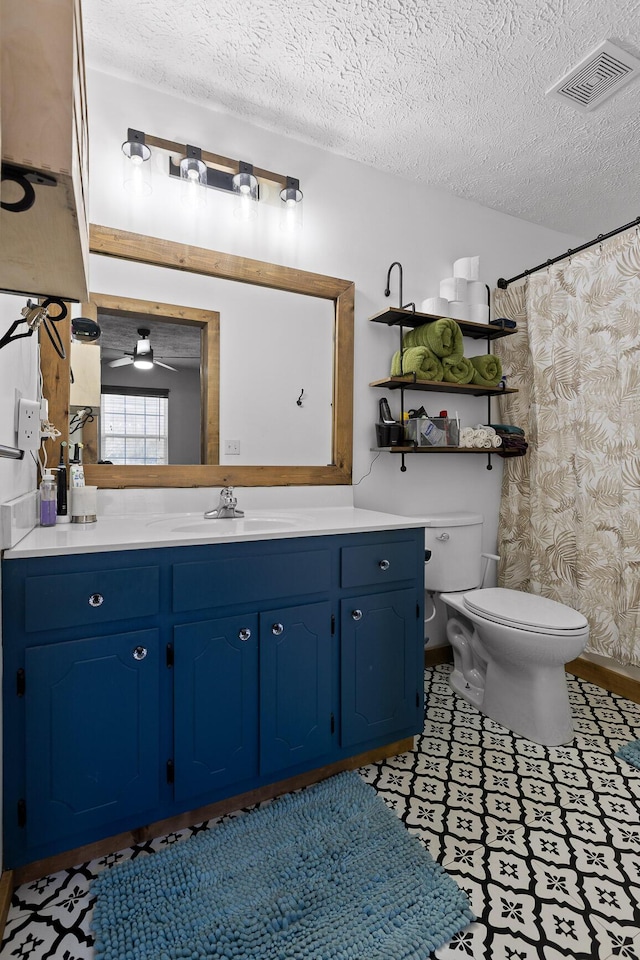 full bathroom featuring visible vents, vanity, toilet, and a textured ceiling