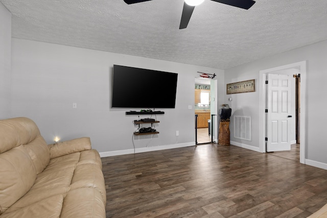 unfurnished living room with visible vents, a ceiling fan, a textured ceiling, wood finished floors, and baseboards