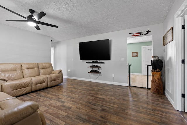 living area with a ceiling fan, a textured ceiling, baseboards, and wood finished floors