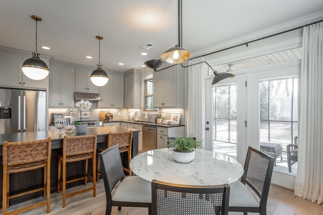 dining room with a healthy amount of sunlight, light wood finished floors, visible vents, and recessed lighting