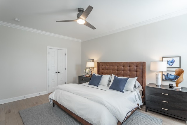 bedroom featuring baseboards, a ceiling fan, crown molding, light wood-style floors, and a closet