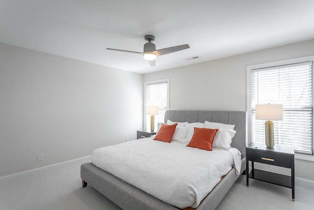 carpeted bedroom featuring visible vents, ceiling fan, and baseboards