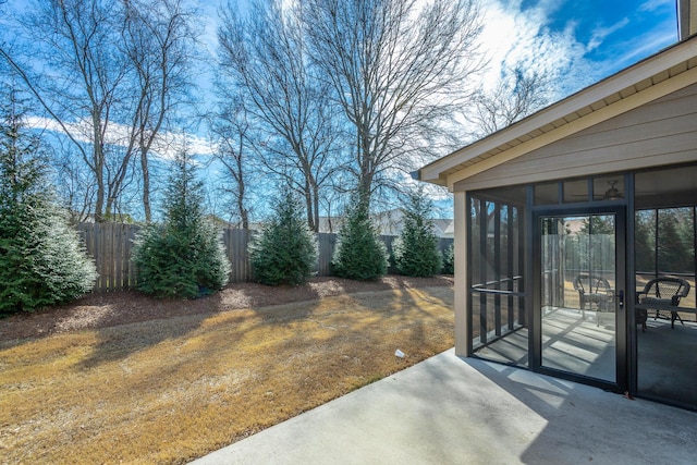 view of yard featuring a sunroom, a patio area, and fence