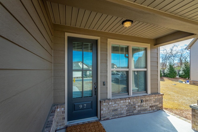 view of exterior entry with brick siding