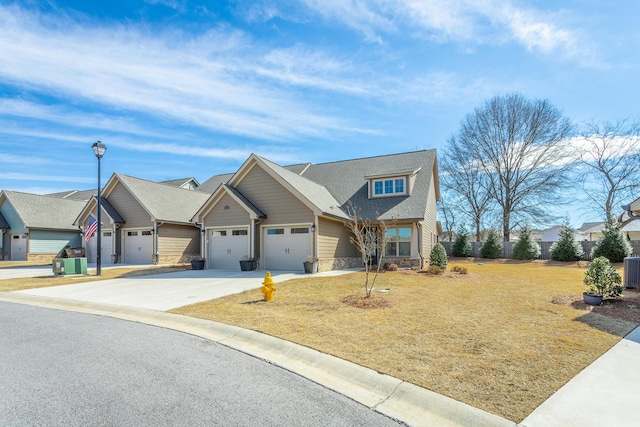 craftsman-style home featuring a front yard, driveway, a residential view, and an attached garage