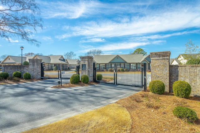 view of street with street lighting, a residential view, a gate, and a gated entry