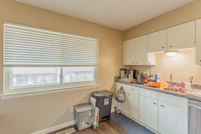 kitchen with baseboards, stainless steel dishwasher, visible vents, and white cabinets