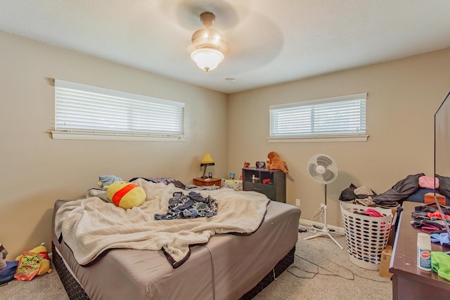 bedroom featuring light carpet, ceiling fan, and baseboards