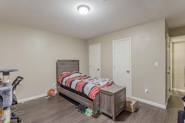 bedroom featuring dark wood-style floors and baseboards