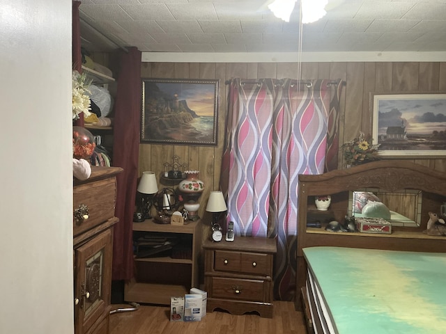 bedroom with wooden walls and wood finished floors