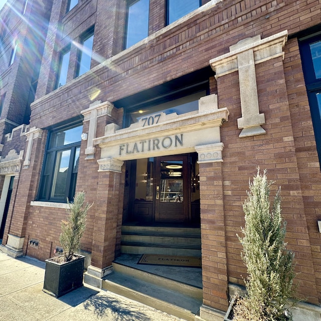 view of exterior entry featuring brick siding