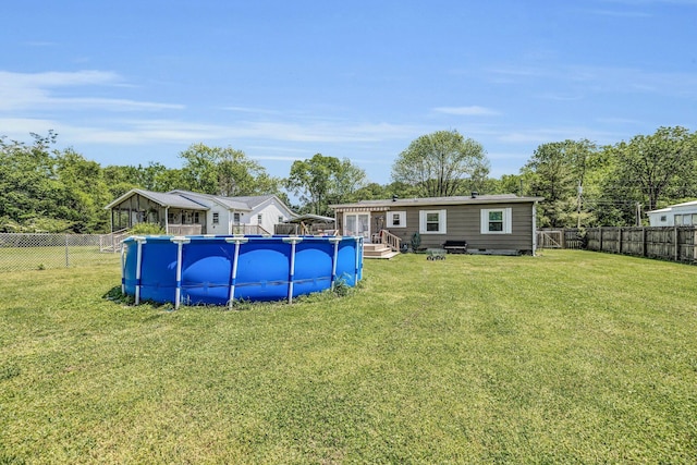 back of property featuring a yard, a fenced backyard, and a fenced in pool