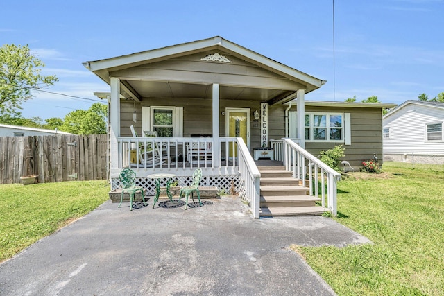 view of front of house featuring fence, a front lawn, and a porch