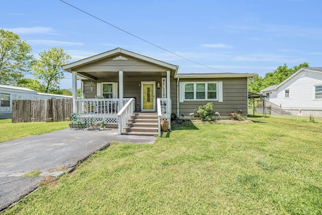 bungalow featuring driveway, fence, a front lawn, and a porch